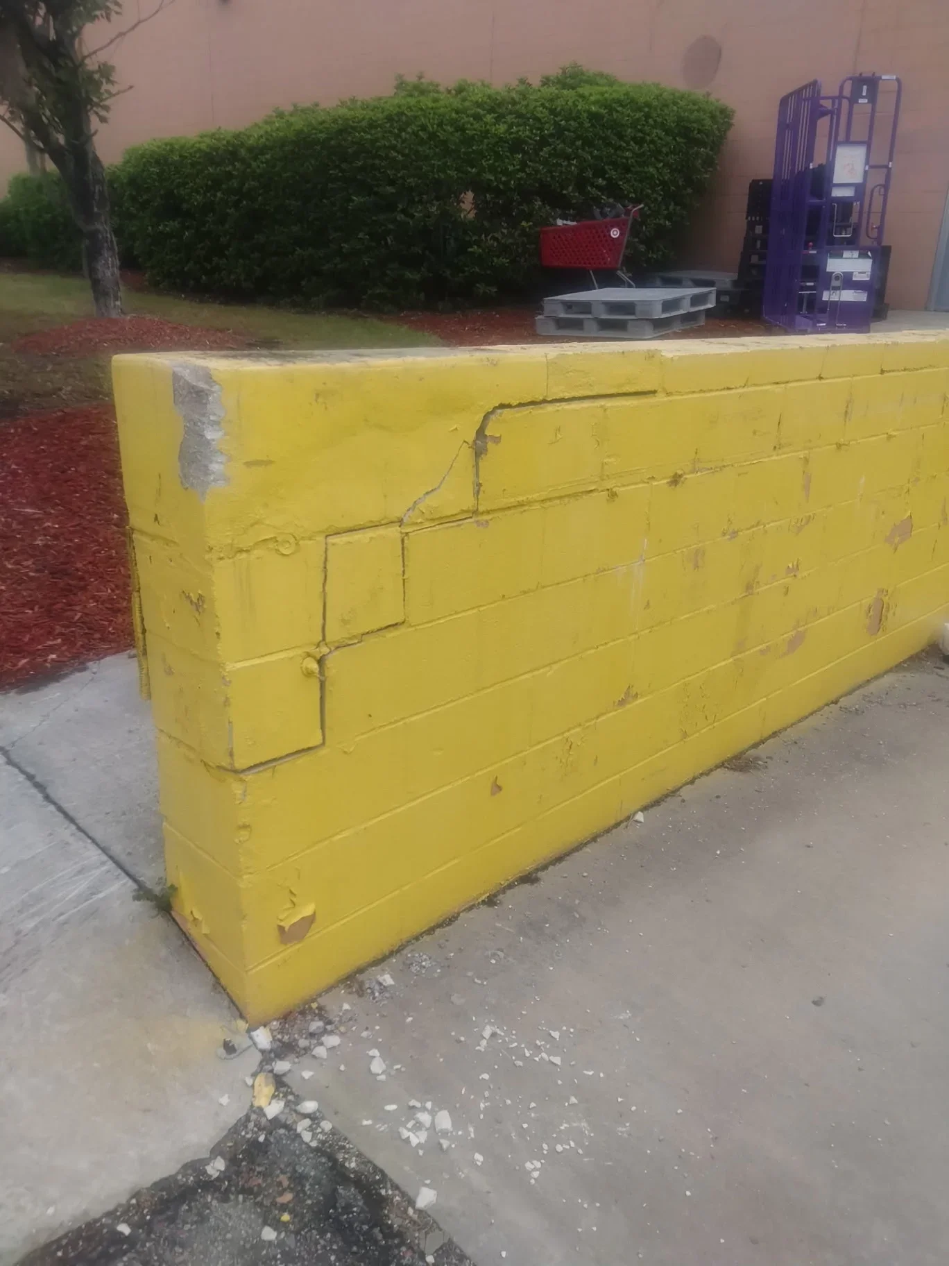 Yellow painted concrete barrier wall with horizontal reinforcement and cable routing system