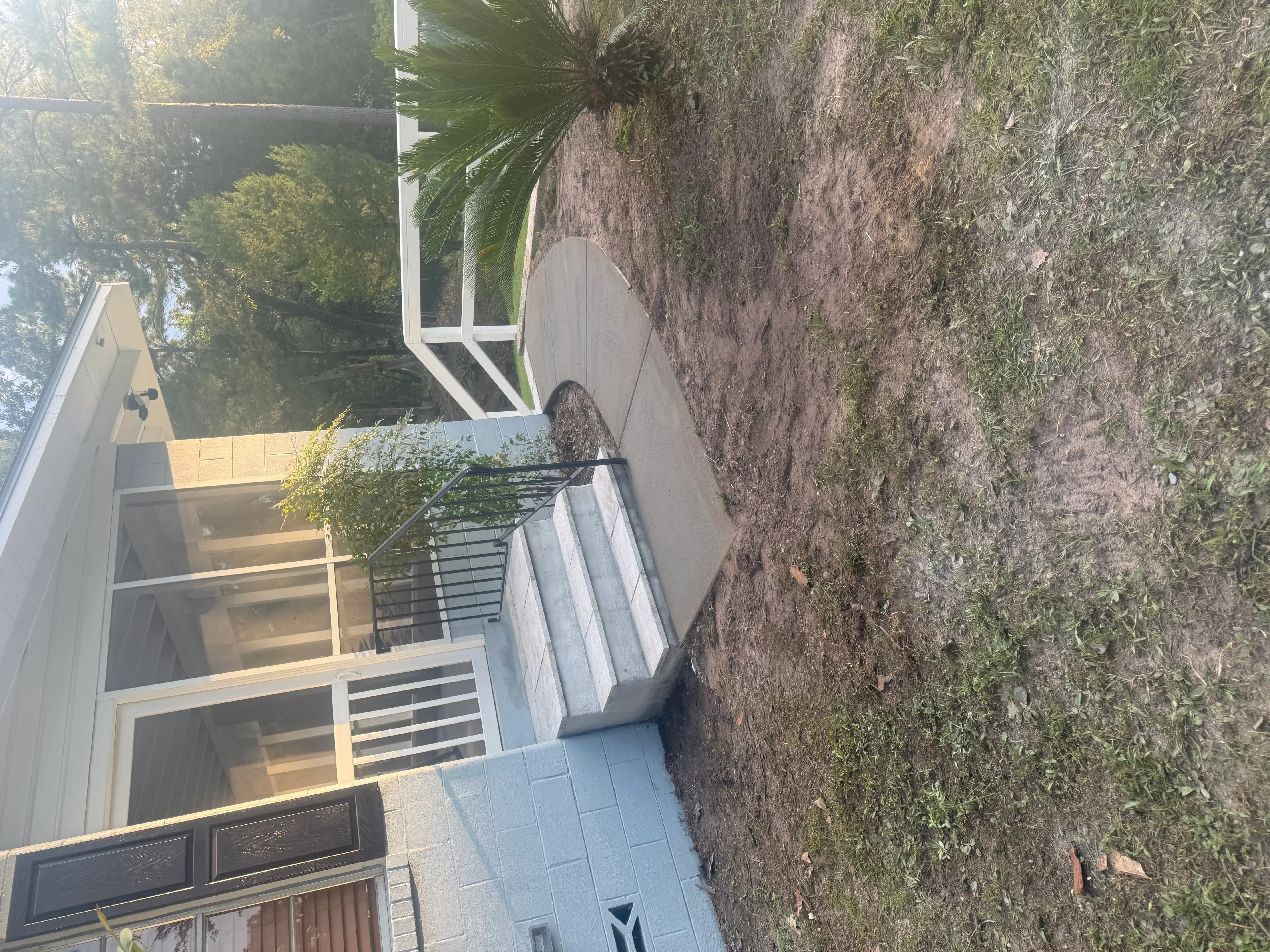 Stamped concrete patio and walkway with metal railing and integrated landscape