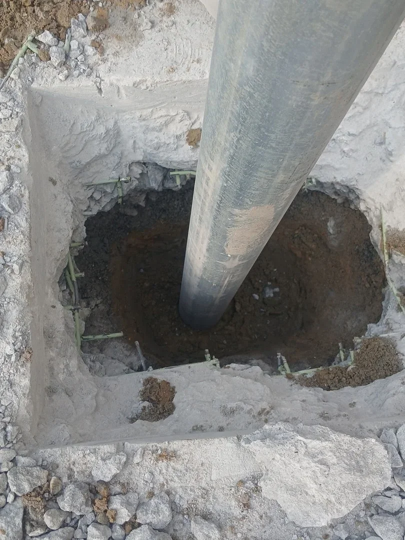 Large concrete pipe installed through concrete foundation with soil bedding and support structure