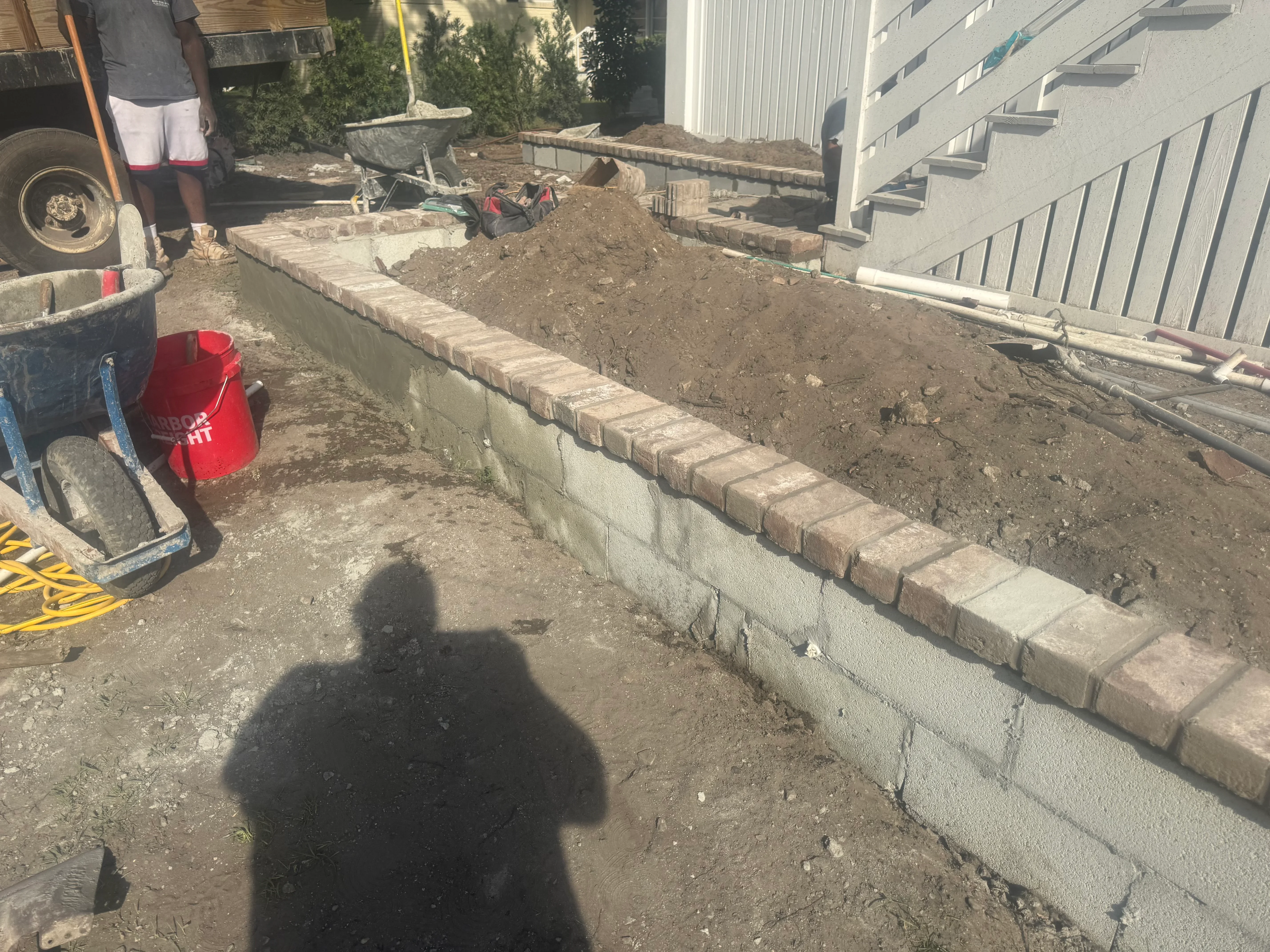 Concrete block retaining wall with brick veneer cap and compacted soil backfill