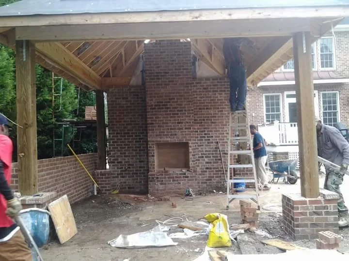Brick chimney foundation with concrete base and wooden patio framing structure